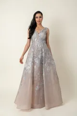 Vestido largo de fiesta color champagne, confeccionado en tul bordado con hilo plateado y detalles de strass.