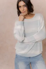 Buzo de tejido liviano con diseño de rayas horizontales en tonos amarillo manteca y blanco, cuello redondo y mangas largas con puños tejidos.