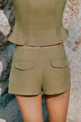 Shorts mini de tiro alto color verde militar, con detalle de botones metálicos y aplicaciones en la parte delantera.