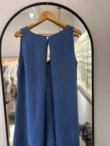 Mono azul de lino, con escote en "V", breteles anchos, corte amplio y abertura en la espalda.