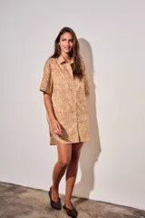 Vestido camisero corto con estampado tipo toile de Jouy a rayas, mangas cortas y cierre frontal con botones.
