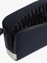 Cartera tipo camera bag Tommy Hilfiger de color azul marino, con compartimento principal con cierre, correa ajustable y desmontable, y parche con el logo de escudo de la marca bordado en el frente.