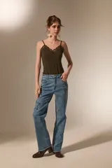 Body de breteles finos color blanco, con escote en V y detalle de encaje en el borde superior. Confeccionado en poliéster, presenta un diseño ajustado al cuerpo con cierre de broches en la parte inferior.