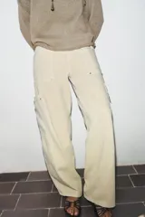 Jeans de tiro medio con diseño cargo, bolsillos de plastrón y pernera holgada que se estrecha hacia el tobillo. Cierre frontal con cremallera y botón.