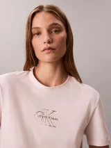 Remera Calvin Klein de manga corta y corte regular, color rosado, con cuello redondo y el logo de la marca impreso en el pecho con efecto metalizado.