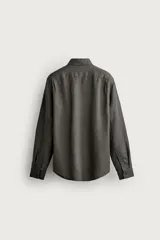 Camisa celeste de lino de corte regular fit, con cuello abotonado, manga larga y cierre frontal de botonadura.