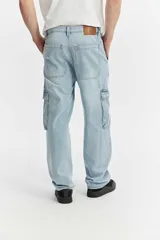 Jean cargo de algodón con calce suelto, color negro lavado con efecto desgastado, con múltiples bolsillos utilitarios en los laterales.