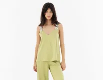 Top de seda y viscosa color verde claro, con escote en V y tirantes decorados con aros concéntricos de nácar.