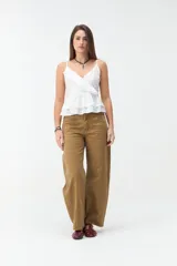 Musculosa blanca de tirantes finos, con escote en V cruzado y detalle de volados en el escote y en el ruedo con diseño de capas.