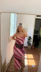 Conjunto de dos piezas compuesto por un top strapless y una falda midi con tajo lateral, ambos confeccionados en tejido elástico con estampado de ondas en tonos rosados, fucsias y violetas.