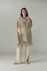 Chal de lana fina con diseño de cuadros pequeños, cierre frontal con alamar y bolsillos de cuero aplicados. Presenta terminación con flecos en el ruedo.