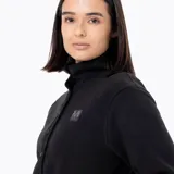 Buzo polar de mujer con cuello alto y cierre frontal parcial con botones a presión. Presenta un diseño de manga larga con puños elásticos y un parche con logo en el pecho.