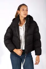 Campera puffer negra con capucha, diseño acolchado y estampado de pequeños puntos brillantes. Cuenta con cierre frontal y tirador decorativo con strass.
