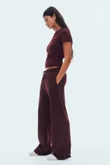 Pantalón de jogging color bordó, confeccionado en felpa con interior cepillado suave. Presenta cintura elástica con cordón ajustable y corte amplio en las piernas, con bolsillos discretos en las costuras laterales.
