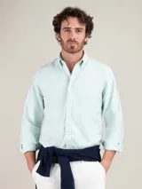 Camisa oxford de hombre color verde menta, con corte regular fit, cuello buttondown y manga larga con puño simple. Presenta cierre frontal de botones y pequeño logo bordado en el pecho.