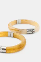 Pack de cuatro pulseras rígidas articuladas con acabado marmolado en tonos tierra. Cuentan con cierre magnético metálico plateado.