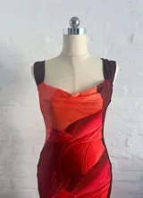 Vestido largo de microtul con estampado abstracto en tonos rojos y naranjas, con escote drapeado y tirantes finos.