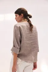 Blusa de lino color lila, de corte relajado y mangas largas amplias, con escote en V y ruedo curvo.