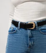 Cinturón femenino de cuero con estructura firme, trabilla reforzada y hebilla metálica de diseño redondeado.