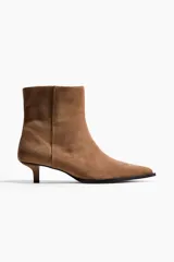 Botines de gamuza color marrón con punta fina y taco kitten. Presentan un diseño minimalista con cierre lateral y forro interior de satén.
