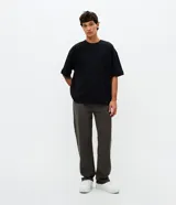 Pantalón de sarga de algodón con acabado vintage, corte recto y ajuste cómodo. Presenta cierre frontal con botón y cremallera, pasadores para cinturón y bolsillos funcionales en la parte delantera y trasera.