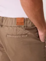 Bermuda de gabardina de algodón color beige, de corte regular, con bolsillos laterales y elástico en la parte trasera de la cintura.