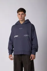 Buzo tipo canguro con capucha, color azul oscuro, de corte oversize. Presenta estampados gráficos en el pecho y bolsillo frontal tipo canguro.