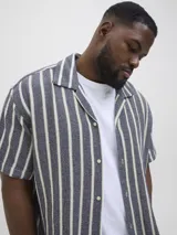 Camisa de manga corta con cuello resort y fit regular. Tejido plano de sarga con textura suave y caída ligera. Cierre frontal con botones.