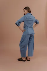 Chaqueta de jean azul, de corte entallado, con cuello camisero, cierre frontal con botones y bolsillos delanteros con solapa.