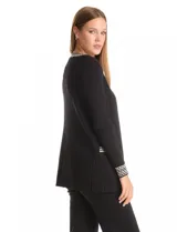 Cardigan de tejido acanalado en color negro, con diseño abierto y manga larga. Presenta detalles de ribete con patrón geométrico en contraste a lo largo de la apertura frontal, en los puños y en los bolsillos simulados.