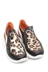 Zapatilla deportiva marrón de cuero liso con detalles en beige y plateado. Presenta cierre lateral y suela gruesa blanca.