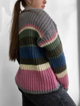 Sweater de punto grueso a rayas horizontales de colores gris, rosa, verde, azul, marrón y crema, con cuello redondo y mangas largas.