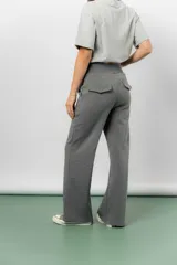 Pantalón blanco de silueta amplia y caída fluida, con cintura alta elastizada y lazo regulable con terminaciones metálicas.