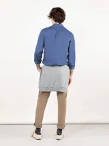 Camisa azul de hombre confeccionada en 100% algodón twill, tintada en prenda. Cuenta con corte regular fit, cuello button-down, cierre frontal de botones, manga larga con puño simple y pequeño logo rojo bordado en el pecho.