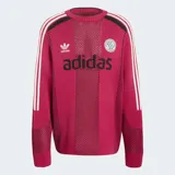 Suéter de punto Adidas en color bordó, inspirado en el estilo de las camisetas de fútbol retro. Presenta cuello redondo, mangas largas con las tres tiras características de la marca en blanco y detalles perforados en la trama. Incluye el logo del Trifolio y un escudo circular bordados en el pecho, junto con el texto "adidas" en contraste.