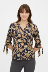 Blusa azul marino con estampado floral en tonos tostados y beige, cuello mao con escote en V y botones frontales parciales. Cuenta con mangas 3/4 terminadas con tiras para anudar en los puños y bolsillos appliquè en el pecho.