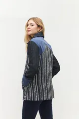 Tapado midi con diseño de combinación de texturas, presenta paneles frontales a rayas verticales en tonos azul, blanco y negro, con detalles en gamuza azul en hombros y puños. Incluye cierre frontal con botones grandes y cuello clásico.