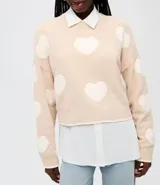 Suéter de punto con diseño de corazones en contraste, cuello redondo y mangas largas con sisa desplazada.