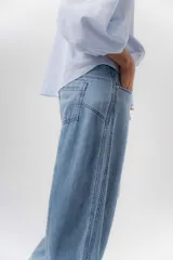 Jean de tiro medio con diseño de pierna amplia y corte holgado, confeccionado en denim azul. Cuenta con bolsillos delanteros y traseros funcionales.