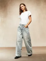 Jean de corte wide leg en color celeste claro con lavado desgastado. Presenta un diseño de cinco bolsillos, incluyendo bolsillos laterales tipo cargo, cierre frontal con botón y bragueta, y costuras reforzadas en las piernas.
