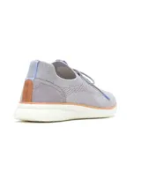 Championes urbanos de tejido knit color gris, con cordones, refuerzo de gamuza en el talón y suela blanca con detalle en color tostado. Incorporan tecnología de amortiguación y diseño flexible para mayor confort.