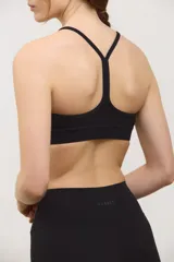 Top deportivo negro de compresión media, con escote redondo clásico, tiras finas cruzadas en la espalda y tazas intercambiables.