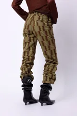 Pantalón de tiro alto confeccionado en pana color óxido. Presenta cierre frontal con botonadura metálica, bolsillos plaqué laterales y diseño de pierna flare.