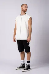 Musculosa oversize de algodón estilo sudadera, color crudo, con costuras visibles en contraste en color negro que recorren el centro verticalmente y enmarcan el cuello y el ruedo.