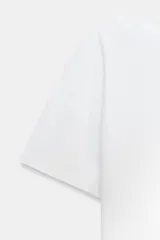 Camiseta blanca de algodón compacto, corte slim fit, con cuello barco y manga corta.