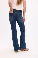 Jean de corte bootcut con tiro medio, confeccionado en denim con elasticidad. Presenta un ajuste entallado en cadera y muslos, con una leve apertura desde la rodilla hacia el ruedo.