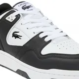 Championes Lacoste modelo Courtcage, de diseño urbano y deportivo. Presentan una combinación de paneles en color blanco y negro, con el icónico logo del cocodrilo bordado en el lateral. Cuentan con cierre de cordones y suela de goma resistente.