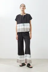 Blusa gris con estampado tie dye, de manga corta y cuello redondo con botones.