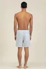 Short de baño celeste con rayas verticales blancas y logo bordado en negro en la pierna derecha.