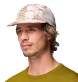 Gorro tipo gorra Columbia modelo Wingmark Cap, con paneles laterales de malla gris y diseño estampado camuflado en tonos rosados y blancos en el frente y la visera. Cuenta con logo bordado de la marca.